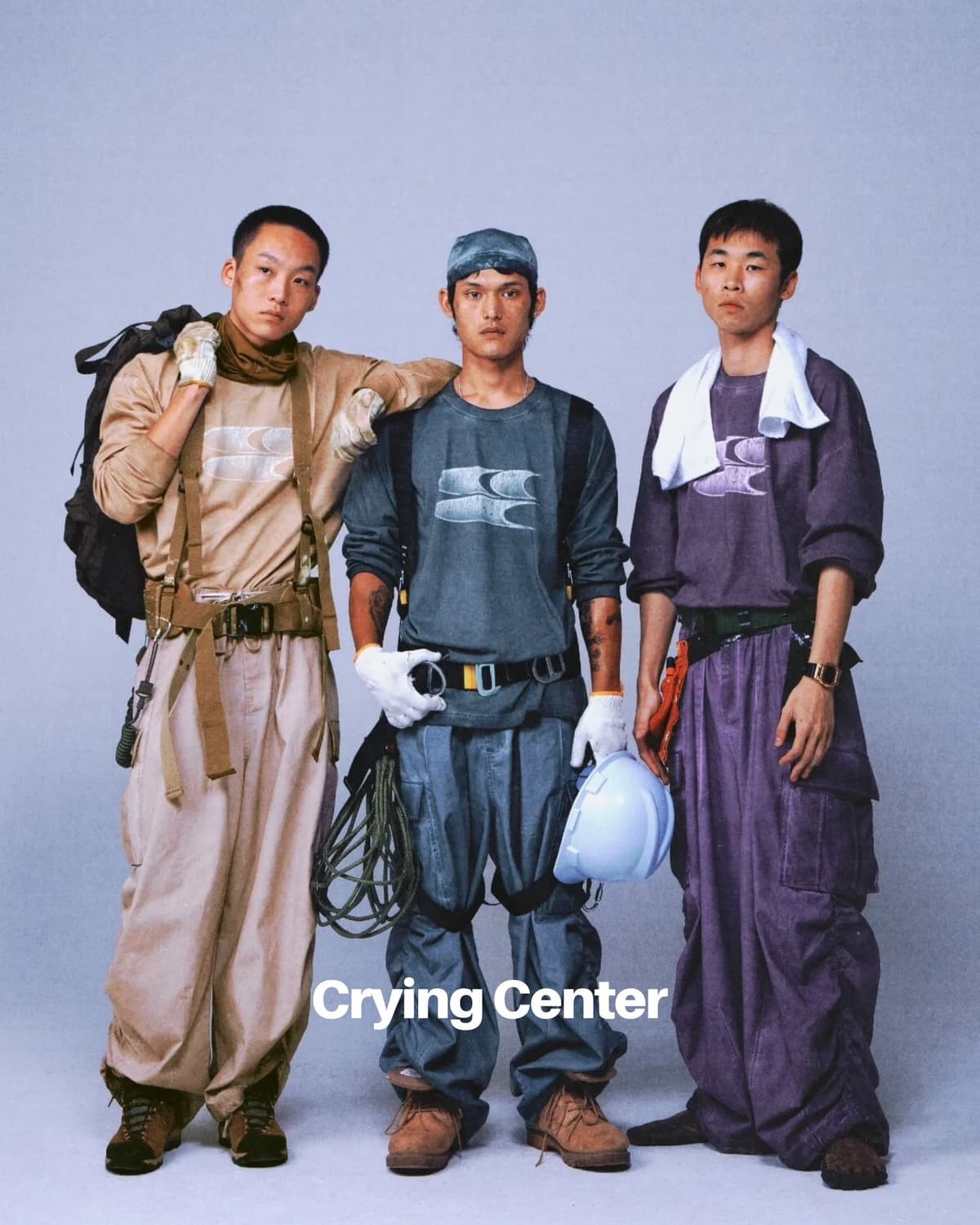 Three Asian men posing in workwear-style fashion, with the text "Crying Center".
