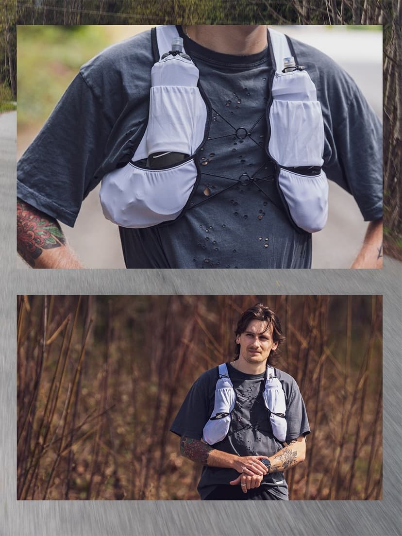 Man wearing a white running hydration vest with water bottles.