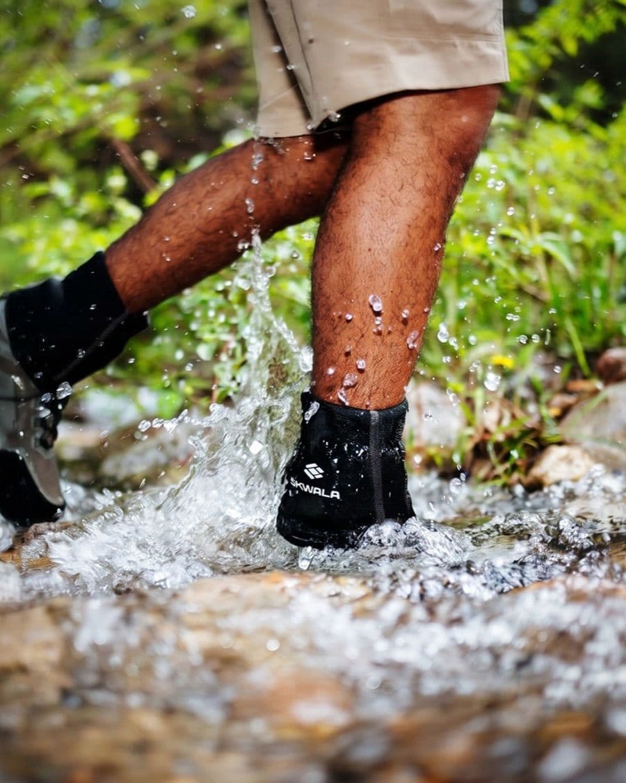 Person wearing SKWALA waterproof socks splashing through water.