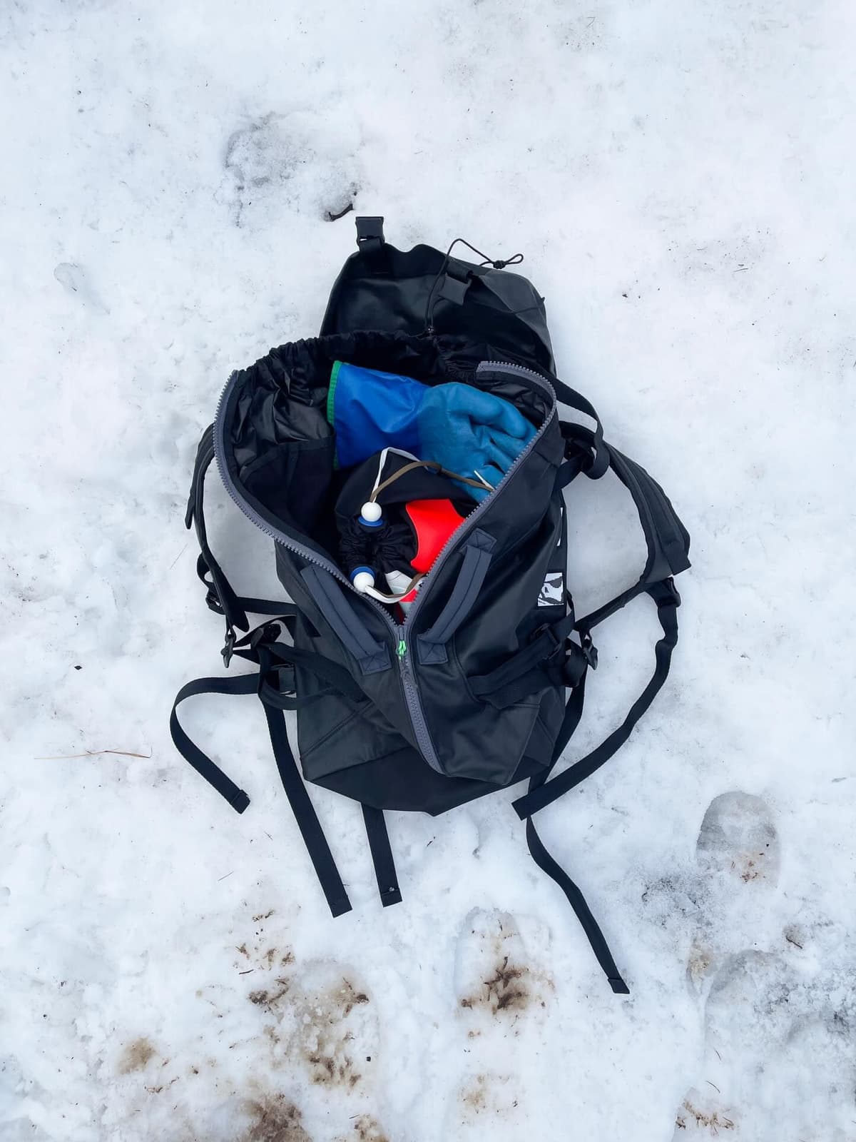 Person in blue shorts and grey socks with orange trim, wearing black hiking boots with extremely long, untied laces.