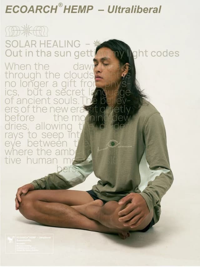 A person with long dark hair meditates cross-legged, wearing an olive green long-sleeved shirt, with "ECOARCH® HEMP – Ultraliberal" text above.