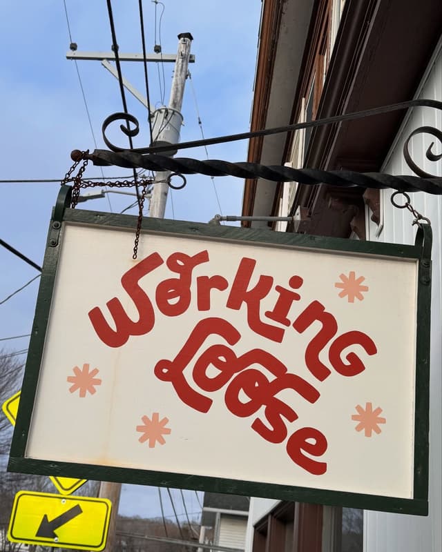A white hanging sign reads "Working Loose" in bold red letters, with pink starbursts.