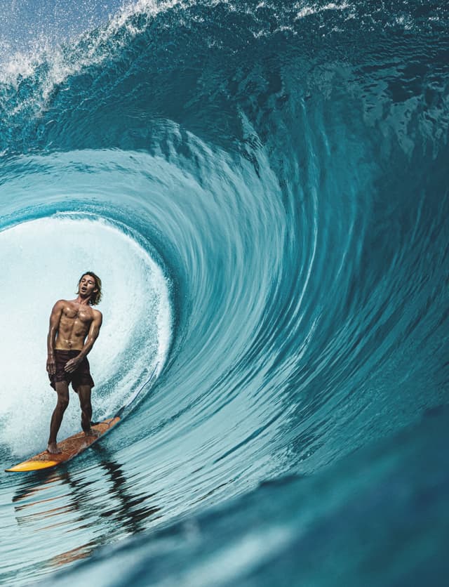 Surfer on a yellow board inside a blue barreling wave for YÜTH mag