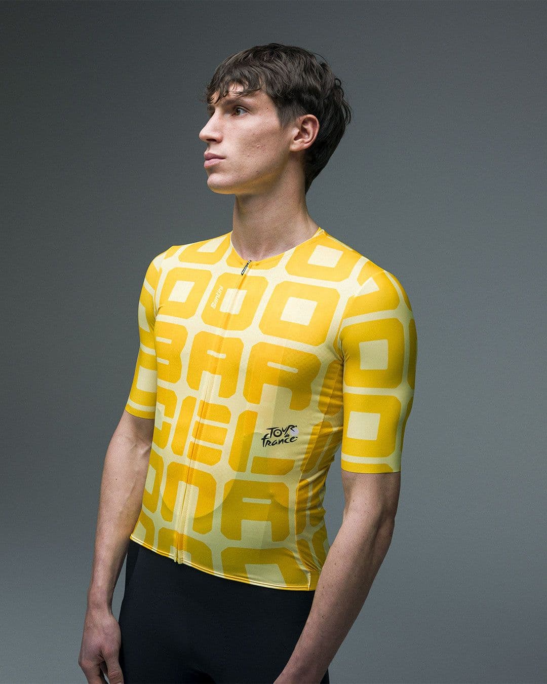 Man in a yellow cycling jersey featuring BARCELONA text and a Tour de France logo.