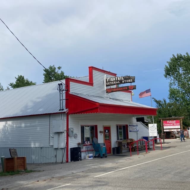 Fishtail General Store, a white building with red trim, flying an American flag.