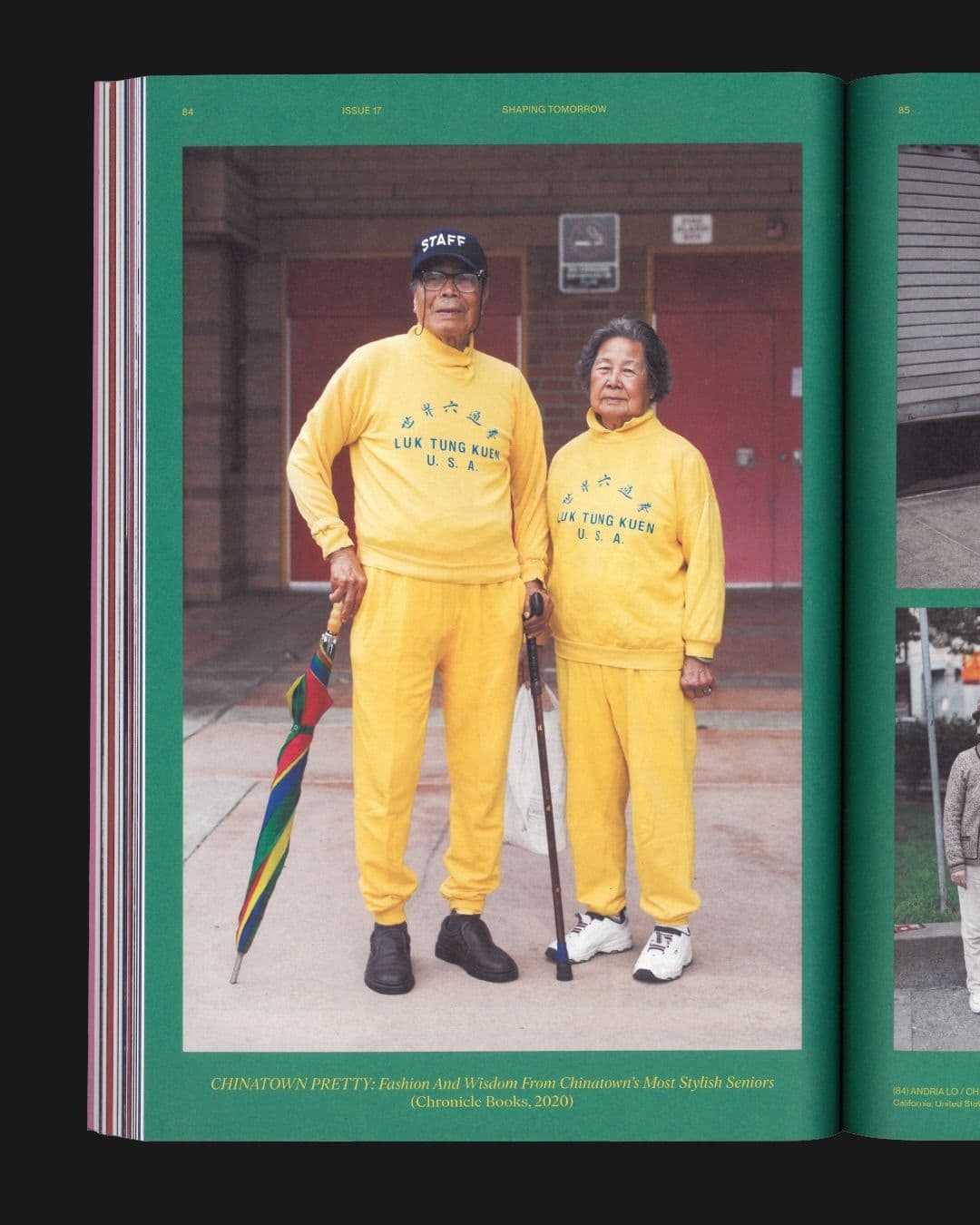 A man and a woman, both elderly Asian individuals, stand in matching bright yellow tracksuits emblazoned with 'LUK TUNG KUEN U.S.A.'. The man wears a 'STAFF' cap and holds a colorful umbrella, while the woman holds a cane for BESIDE Magazine