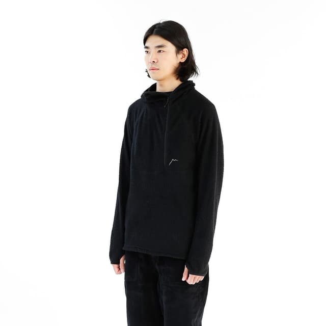 Man wearing a black textured fleece pullover with a partial zipper and a white mountain logo.