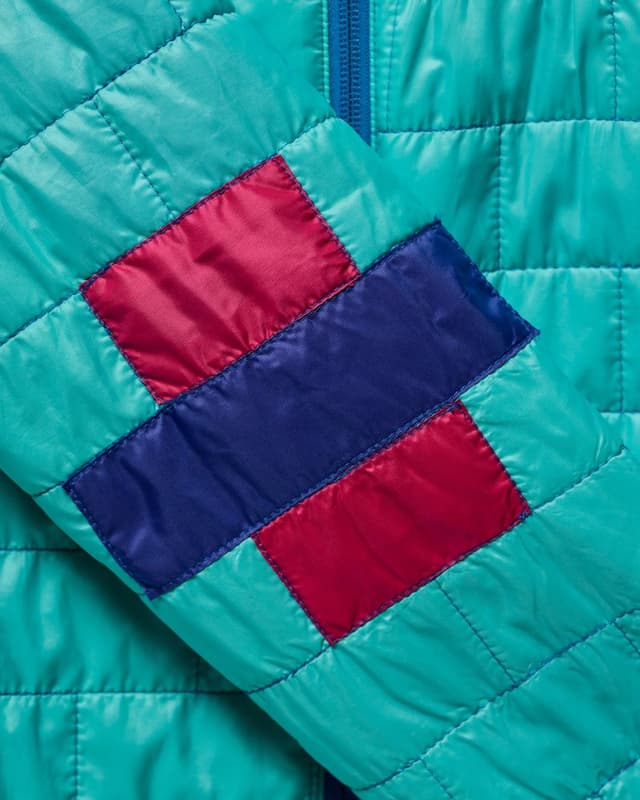 Teal quilted jacket sleeve with magenta and blue rectangular patches.