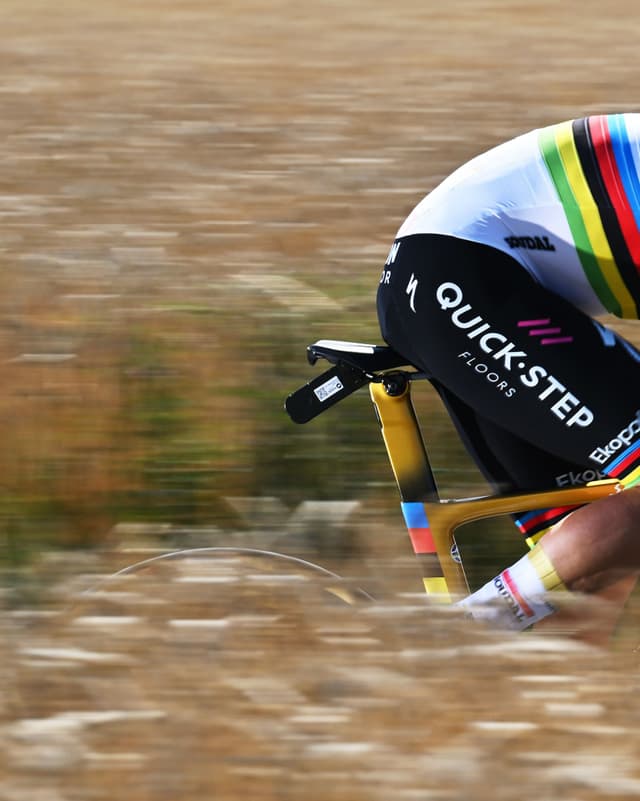 Quick-Step Floors cyclist on a time trial bike, blurred for speed.