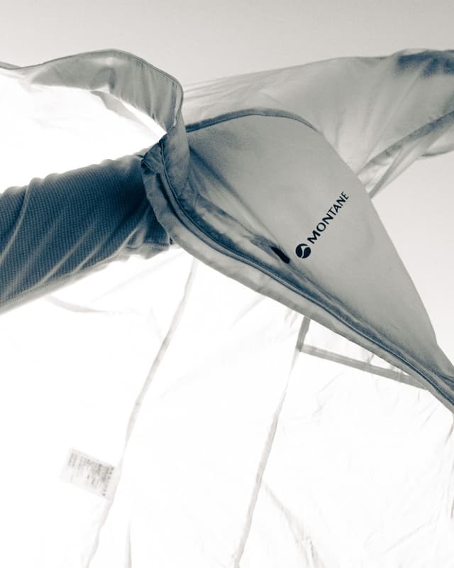 Close-up, black and white photo of a translucent fabric with the 'MONTANE' logo, backlit against a bright background.