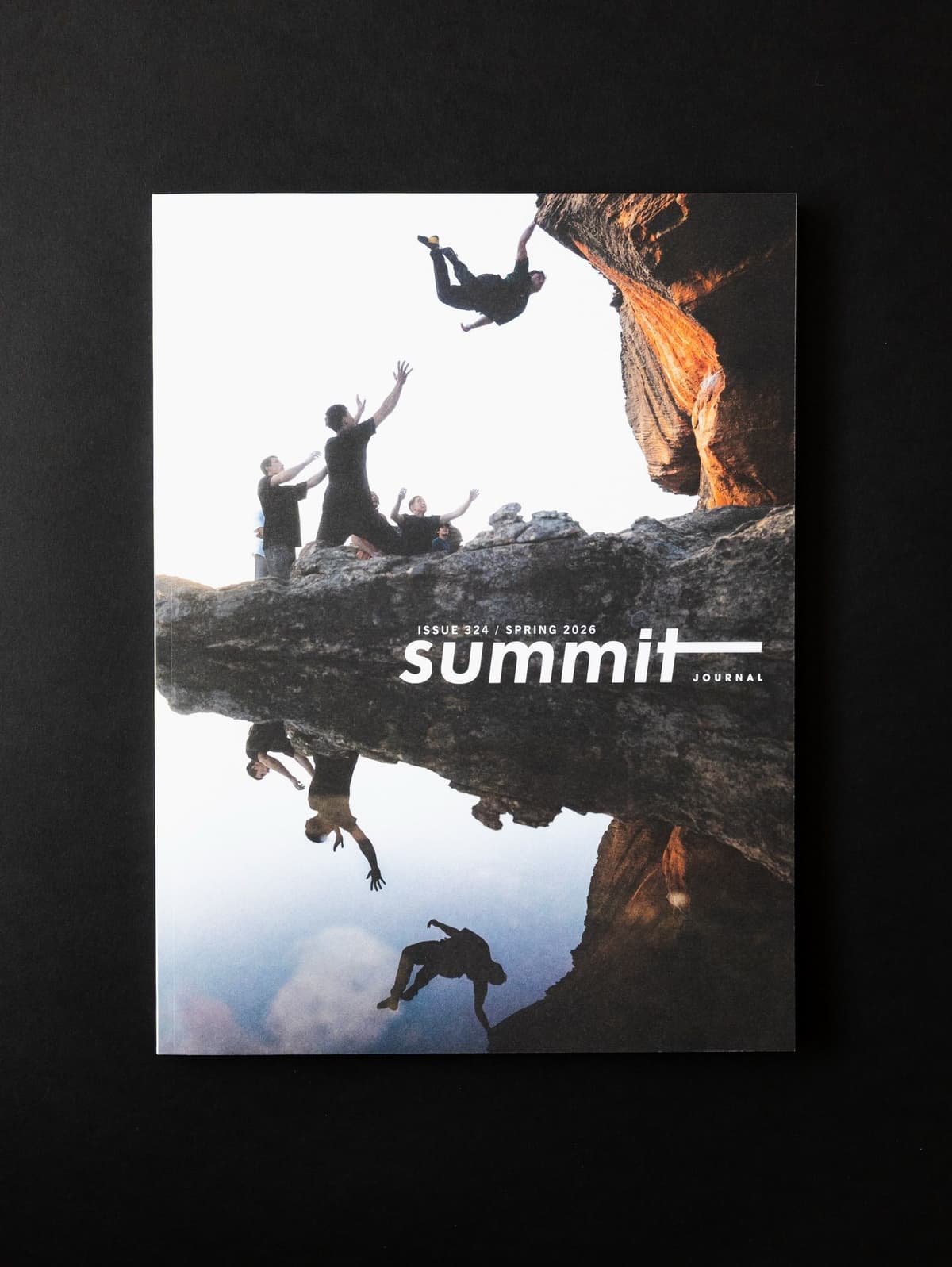 Cover of Summit Journal magazine featuring rock climbers, one hanging upside down, above a reflected scene.
