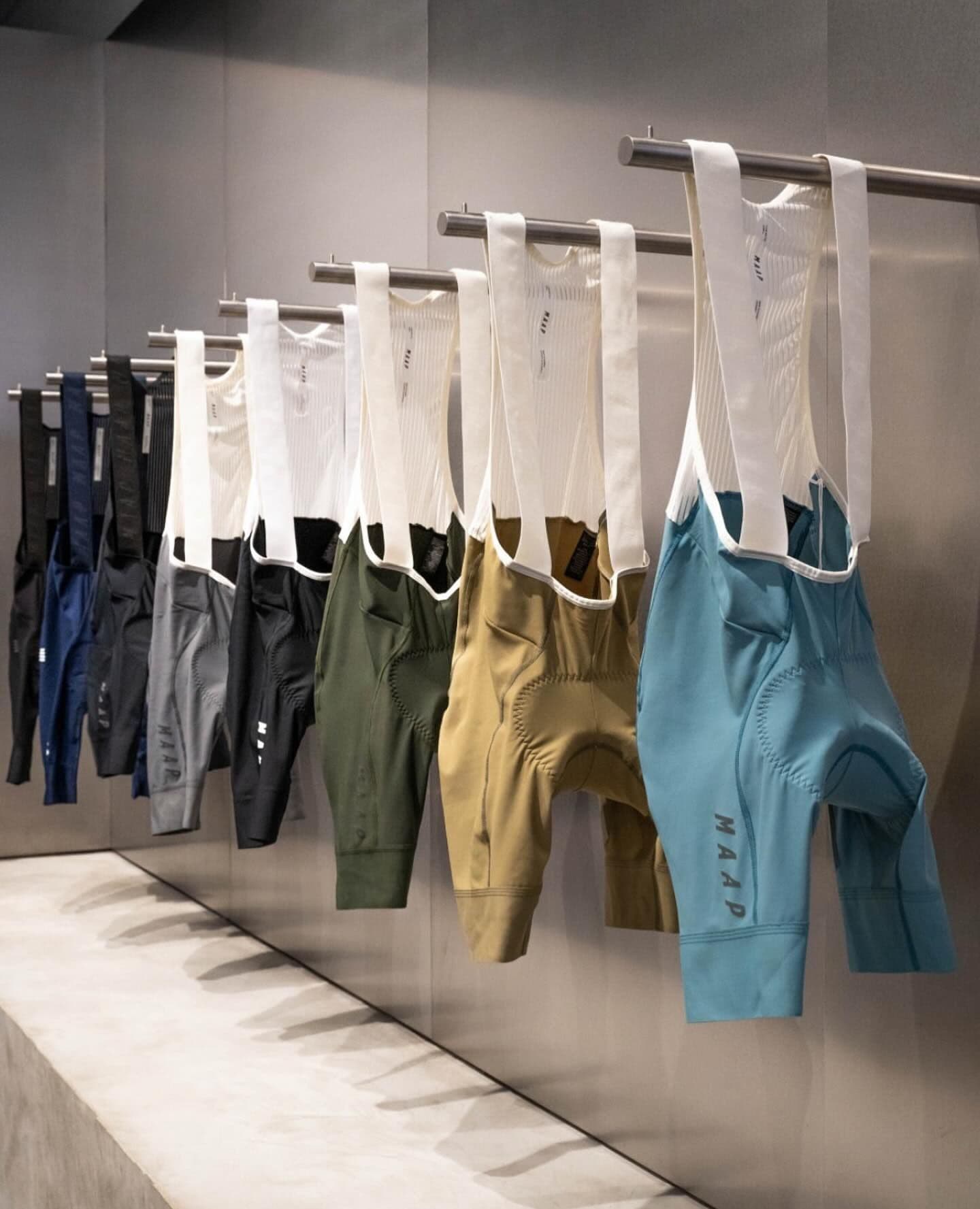 Colorful MAAP cycling bib shorts displayed on a rail.