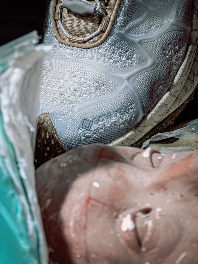 Frosted white GORE-TEX sneaker with a blurry face below.